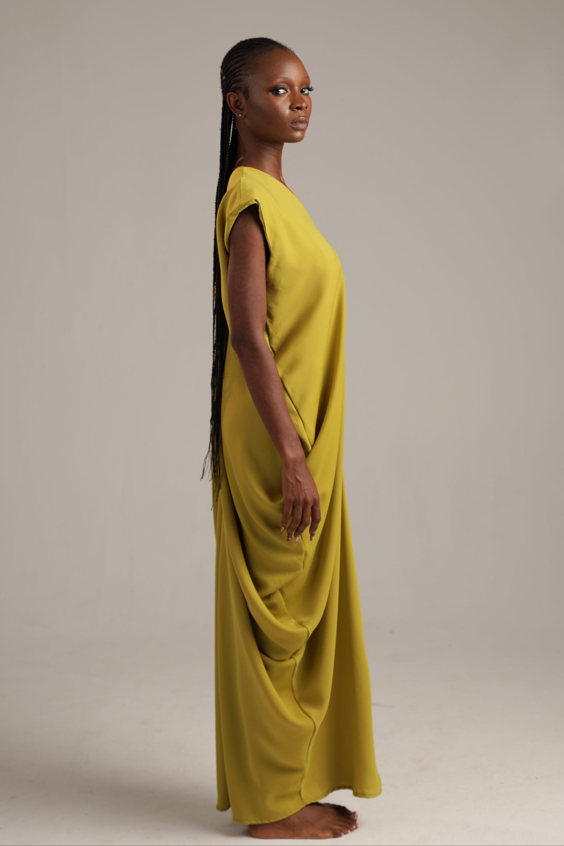 Woman wearing a yellow dress against a plain background