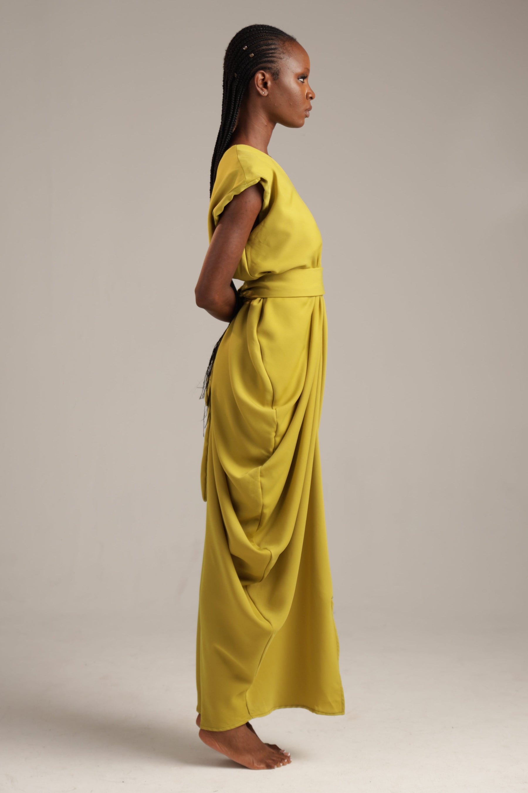 Woman wearing an olive green dress against a plain background