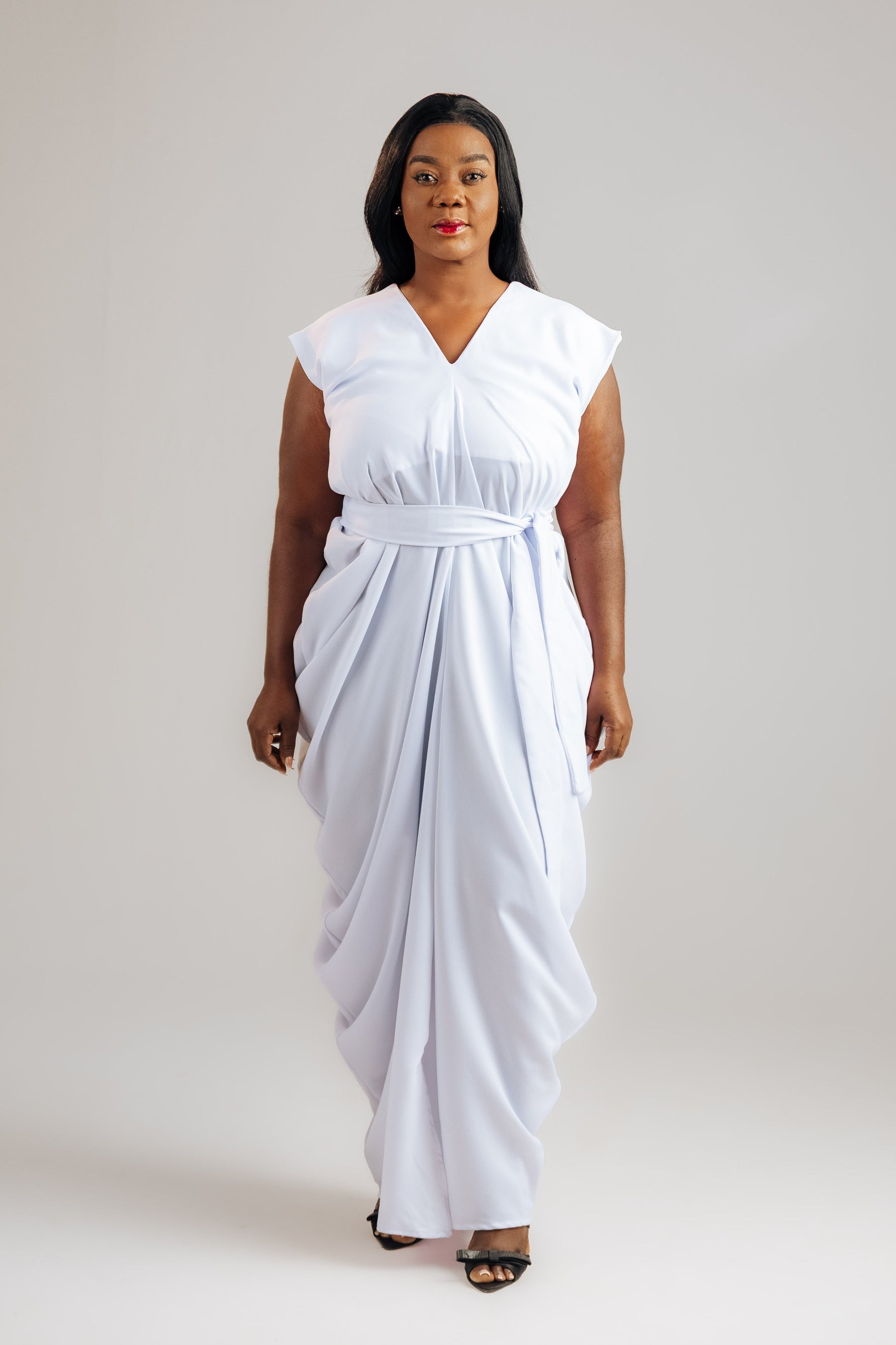 Woman wearing a white dress against a plain background
