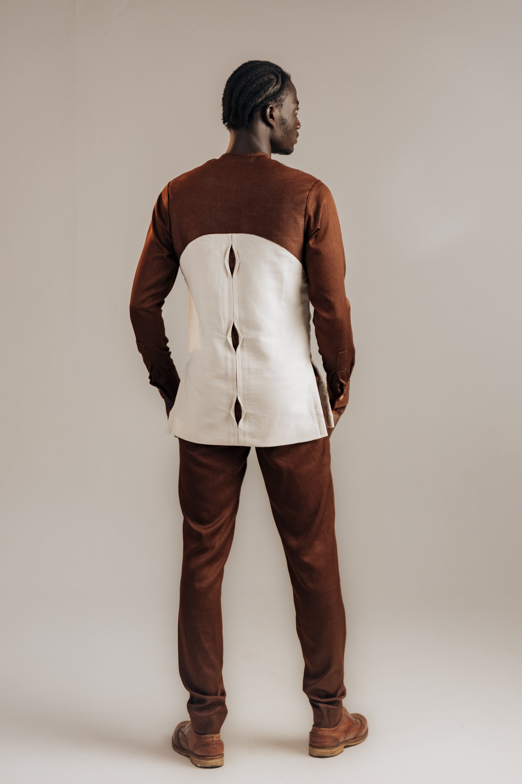 Person wearing a brown and white outfit against a plain background
