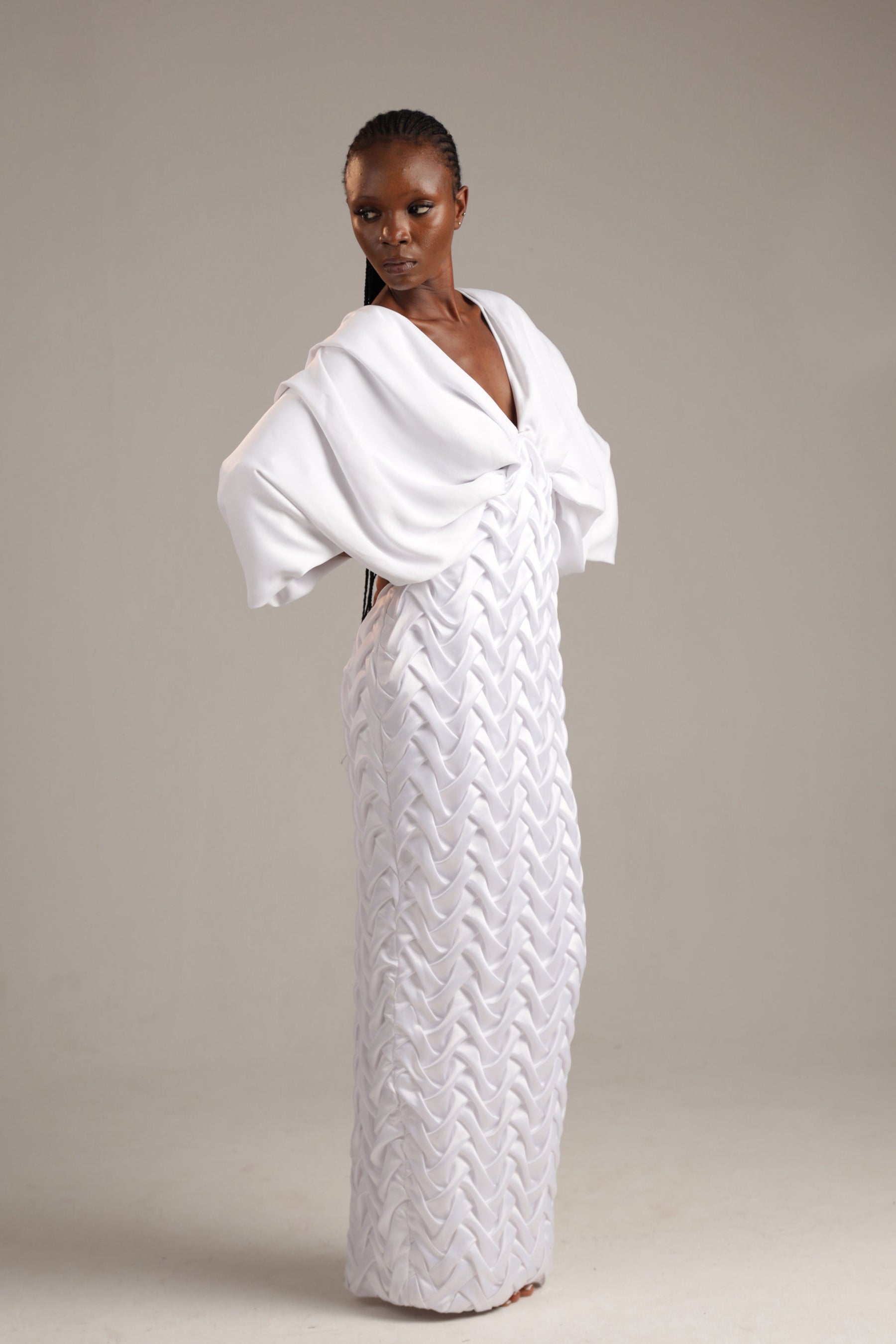 Woman wearing a white textured dress against a plain background